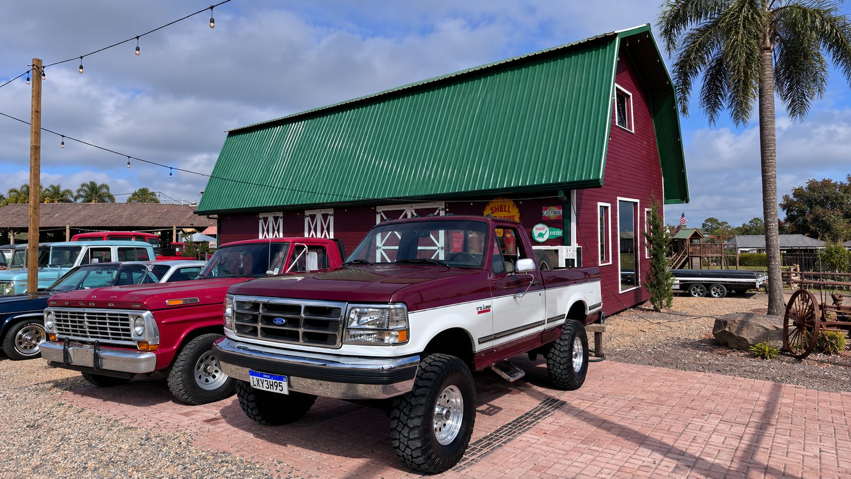 F-1000 diante de um celeiro vermelho, entre outras picapes clássicas